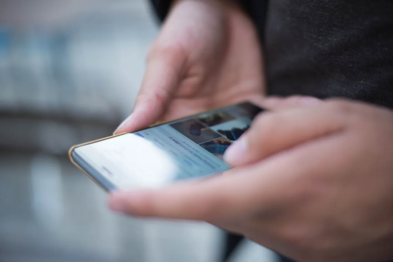 Hands scrolling social media on a phone